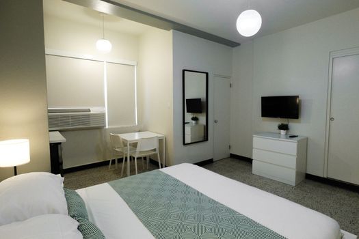 This functional yet comfortable space offers a cozy bed, ample storage, and a small table, perfect for catching up on work or enjoying a quiet meal.