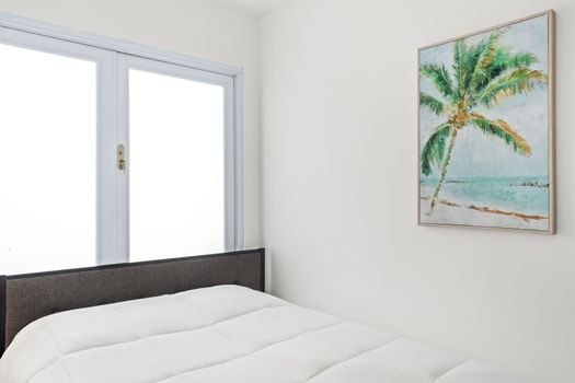 A bedroom with a view of the sea, a comfortable bed, and a chic Acapulco chair.