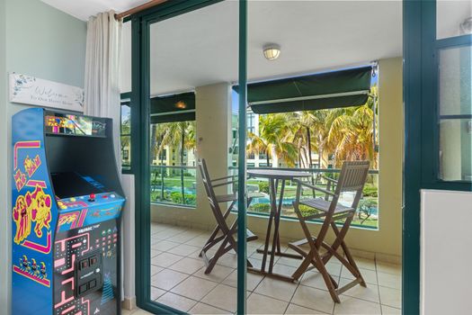 Step out to the breezy balcony with direct views of the serene community pool and lush tropical gardens.