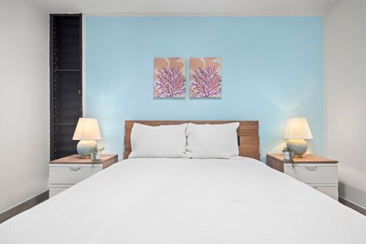 Plush queen bed, stylish nightstands & captivating art. Your serene sleep sanctuary.