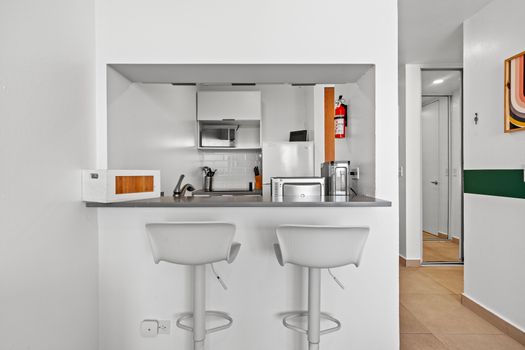 Enjoy the convenience of modern appliances and stylish seating in a compact, efficient space.