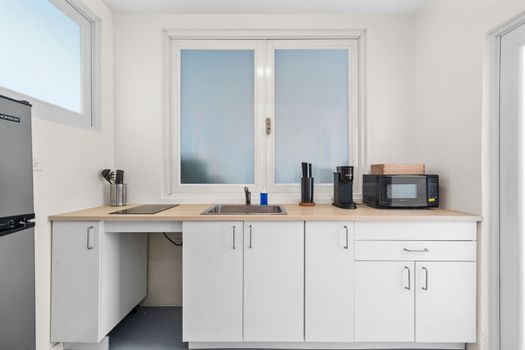 Streamlined kitchenette with modern appliances, providing all you need to whip up a quick meal or a hot cup of coffee before exploring.