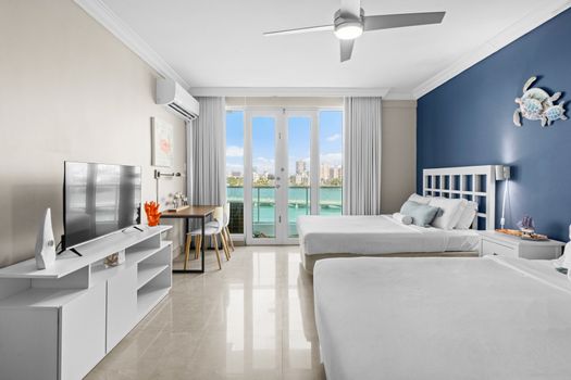 This vibrant and airy studio offers direct access to a private balcony overlooking the water, providing an idyllic setting for morning coffee or evening relaxation.