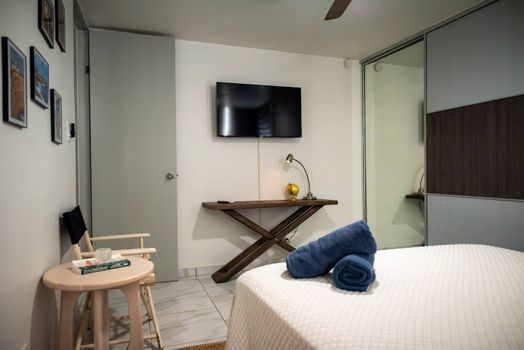 Enjoy a comfortable stay in this well-equipped room! Relax with a mounted flat-screen TV, a practical desk area, and a large sliding closet for all your belongings.