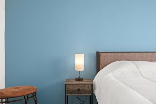 Experimente la tranquilidad en este elegante dormitorio caracterizado por sus elementos de diseño contemporáneo, su acogedora cama y su llamativa pared azul.