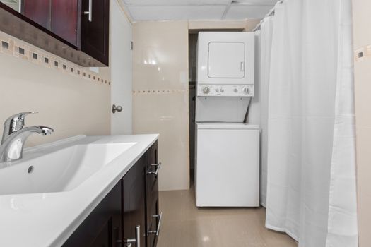 The sink basin is crafted from white ceramic, complemented by a matte black faucet with a waterfall spout.