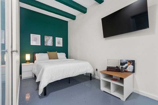 Rest easy in our serene bedroom with a vibrant emerald feature wall, complete with all the comforts of home and a hint of musical history.