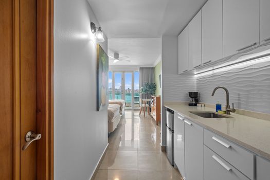 Sleek and functional: a bright white kitchenette designed for easy meal preparation during your stay.
