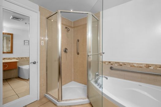 Experience comfort and convenience in this well-appointed bathroom, offering both a spacious walk-in shower and a corner bathtub for your relaxation needs.