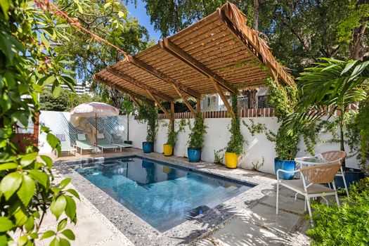 huge  refreshing pool with sunbathing beds and chairs, terrace with gazebo