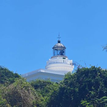 Discover a local landmark! This beautiful lighthouse stands tall against a clear blue sky, a guiding light and a picturesque sight on the Malolos coast.