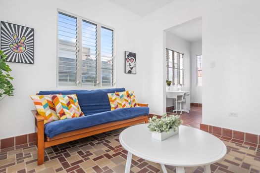 A warm living room with a view, a side table, and a painting.