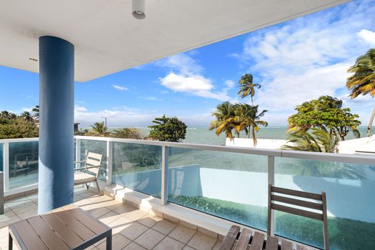 Comience el día con tranquilas vistas al mar y un entorno de palmeras desde este amplio balcón.