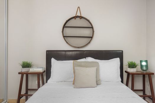 Unwind in style in our chic bedroom, boasting a luxurious queen bed with plush pillows, an elegant leather headboard, and unique wall art.