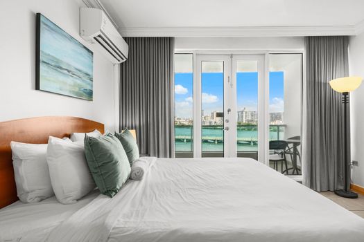 Your perfect escape: a cozy bed with a spectacular backdrop of the lagoon and city skyline.