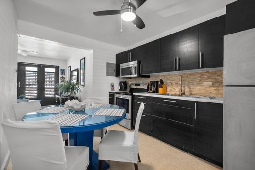 Culinary Delights Await: Our fully-equipped, modern kitchen with an inviting island and seating is perfect for preparing delicious meals and enjoying morning coffee.