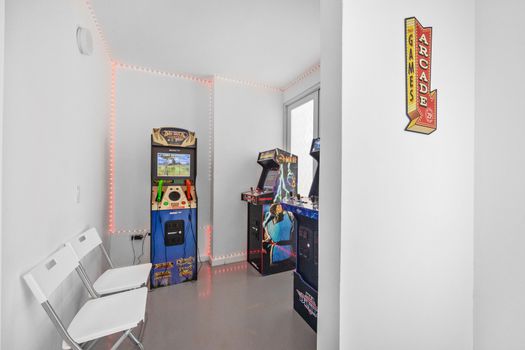 Unleash your inner gamer in this bright, inviting space adorned with iconic arcade machines and illuminated by enchanting LED lights.