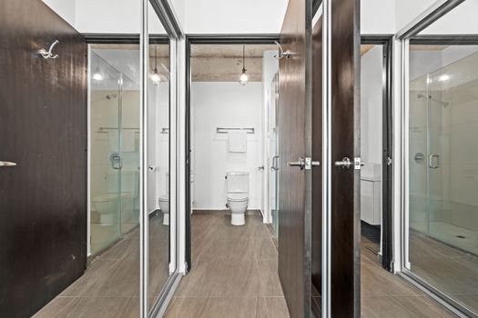 Streamlined bathroom design featuring glass shower doors and polished fixtures, reflecting a modern urban style.