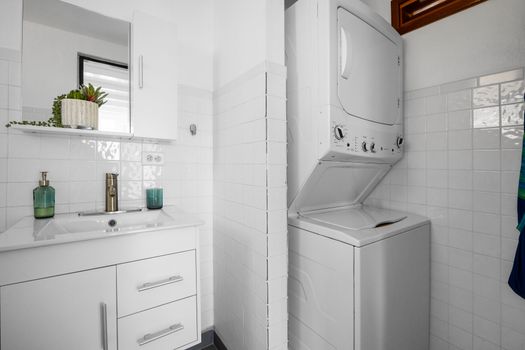 Refresh in the modern bathroom with a spacious shower, stylish vanity, and built-in laundry area – great for extended stays or packing light.
