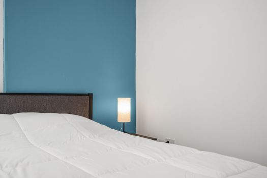 Unwind in a stylish, modern room with a cozy queen bed set against a vibrant blue accent wall.