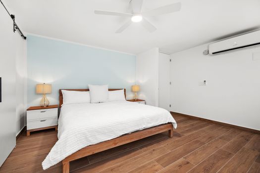 Spacious bedroom with a stylish dresser, ceiling fan & A/C for comfort.