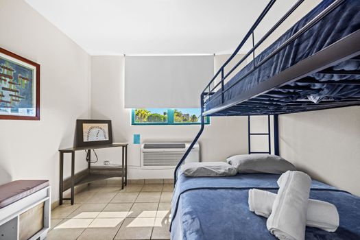 Stay in our minimalist room offering a comfortable bunk bed, ample lighting, and a picturesque view through the expansive windows.