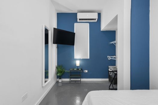 Nuestra habitación cuenta con una acogedora cama con sábanas blancas impecables contra una pared decorativa en azul intenso, lo que ofrece un refugio tranquilo para los exploradores de la ciudad.