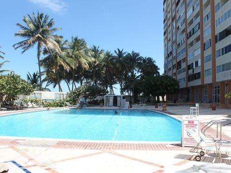 Relax poolside under swaying palms with direct access to the beach—your tropical escape awaits.
