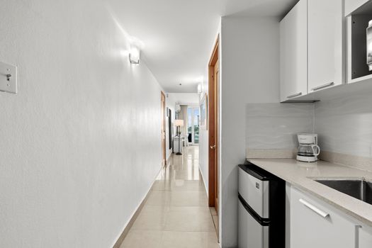 Inviting hallway with a glimpse of your bright, well-appointed studio and convenient kitchenette.