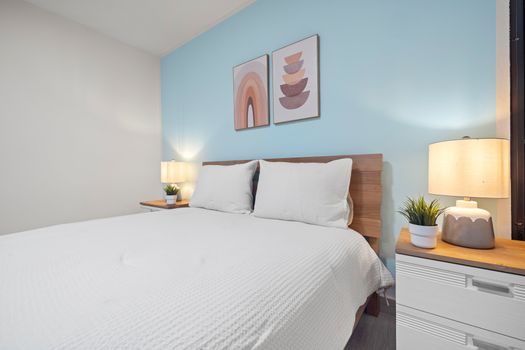 Cozy bedroom with a calming blue accent wall, perfect for relaxation
