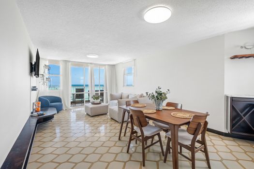 Embrace coastal living! The spacious living area boasts floor-to-ceiling windows, seamlessly blending indoor comfort with the magnificent oceanfront scenery.