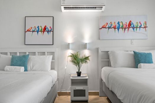 Charming studio with two comfortable beds and a private balcony for mesmerizing ocean views. Enjoy vibrant decor and comfort.