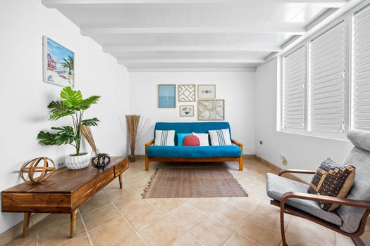 Sun-filled living room with a comfy couch and large windows – great for lounging and relaxing.