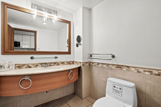 Step into our thoughtfully designed bathroom, featuring a stylish vanity with ample counter space and a large mirror. Every detail is considered for your comfort and convenience, with an accessible layout