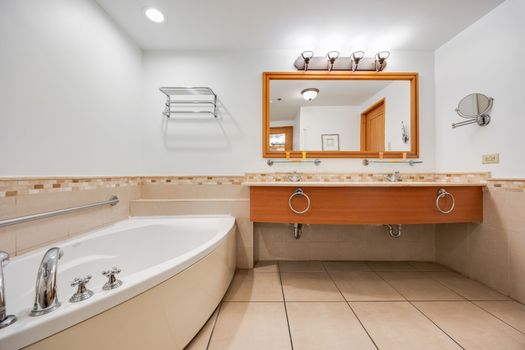 Bright and spacious, our bathroom offers a sophisticated design with beautiful tile accents and a large, well-lit mirror to get ready in comfort.