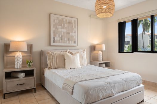 Relax in the spacious master bedroom featuring a plush Queen bed and direct access to your private balcony.