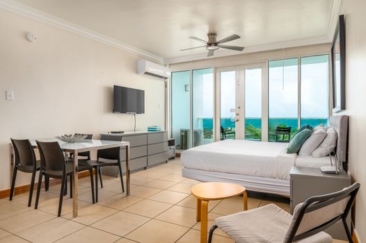 Perfect for extended stays! This studio features a large bed, dedicated dining space, and a well-equipped kitchen area.
