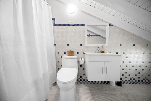 Clean, coastal, and charming. Bright bathroom with fun tile details and everything you need to refresh after a beach day.