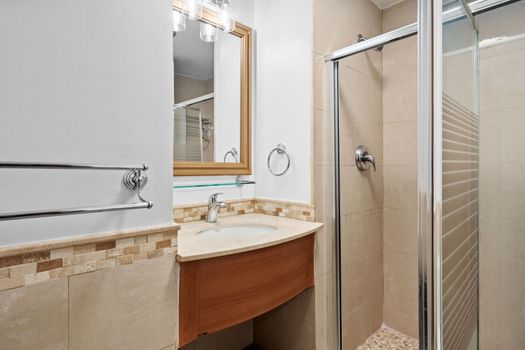 Modern and pristine bathroom featuring a vanity with a stylish mirror and a refreshing shower.