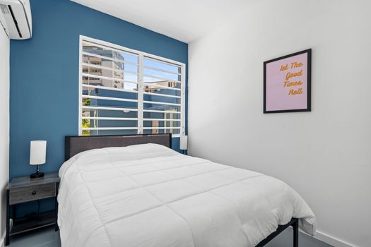 A spacious, sunny room with a blue wall, white rocking chairs, and a world map, offering a comfortable and colorful place to unwind.