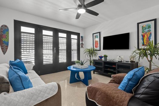 Serene Slumber: Drift off to sleep in this peaceful bedroom, featuring comfortable bedding and charming dark shutters for a perfect night's rest.