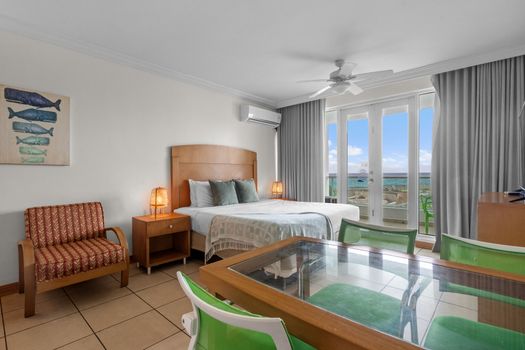 Designed for serene getaways. Experience the best of Condado Lagoon with this bright, airy bedroom featuring a comfortable queen bed and immediate access to your scenic balcony view.