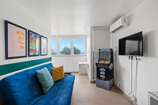 Chill out and enjoy the ocean views from our vibrant living room, complete with a classic arcade game for endless entertainment.