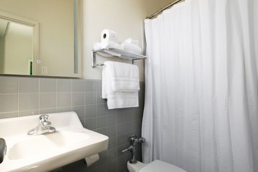 Freshen up in our neat and well-maintained shower area, complete with a clean shower curtain and easy access to towels for your convenience.