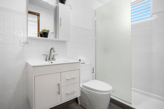 Enjoy a clean and well-maintained bathroom featuring modern fixtures, a sleek vanity with storage, and a bright shower space.