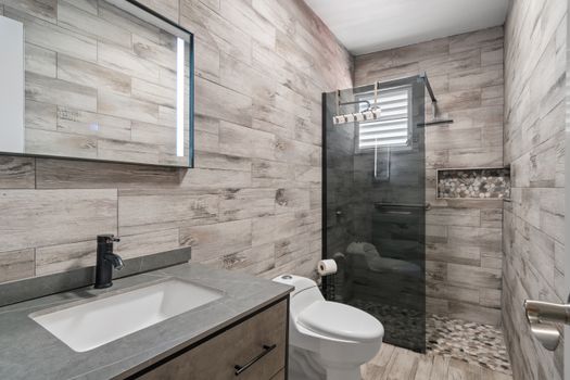 Luxurious bathroom featuring stunning wood-look tile throughout.