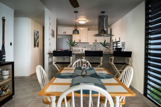Experience our spacious open-concept living! This inviting dining area flows seamlessly into a well-equipped kitchen, perfect for meals and socializing during your stay.