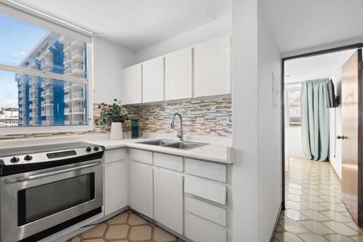 Enjoy the convenience of home cooking while on vacation! This bright kitchen offers a modern stove, microwave, and plenty of storage, making meal prep a breeze.