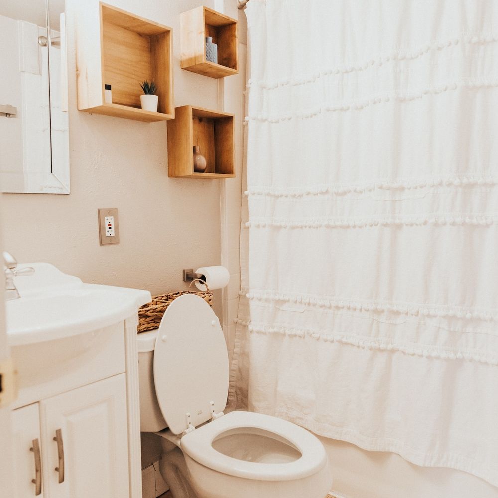Full bathroom downstairs with wall shelving for storage