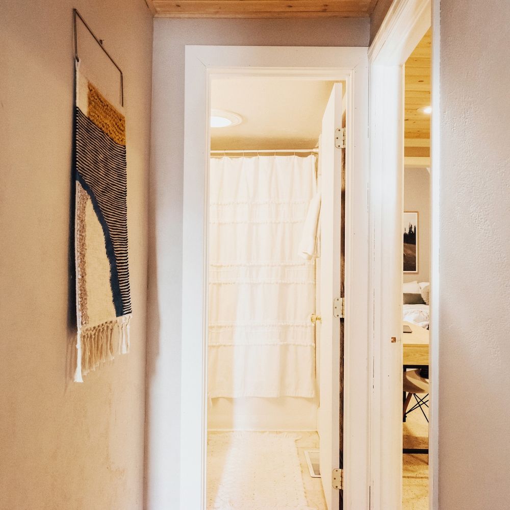 Hallway from kitchen; full bathroom ahead, game room to the right